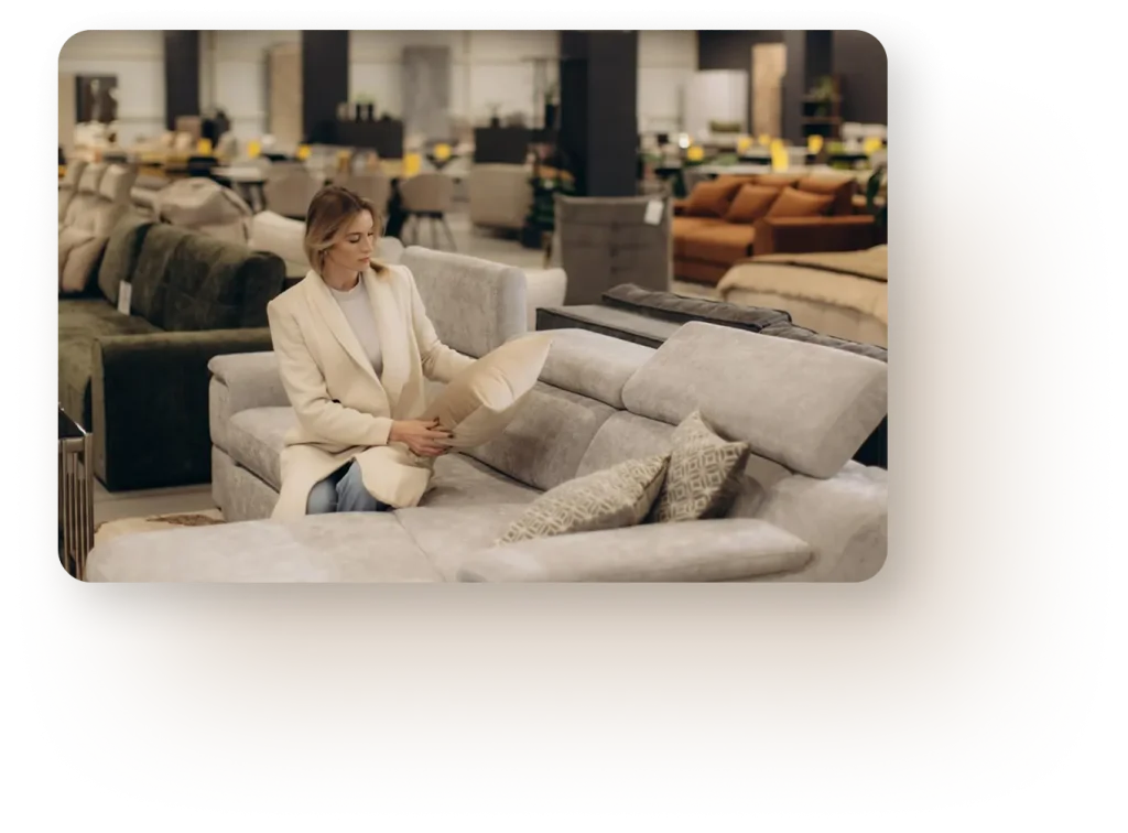 nő bútoráruházban ülve lakberendezési elemeket néz